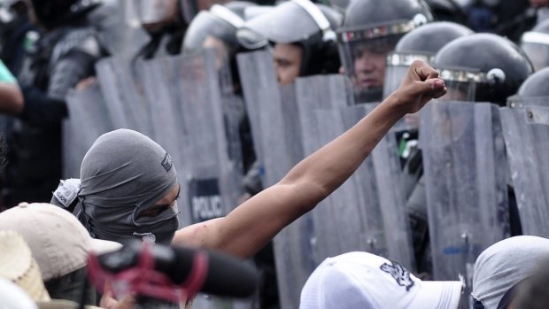 Protesters in Mexico demanding action on the missing 43 students are confronted by riot police in November last year. 