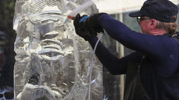 Glenn Smith at work on his ice sculpture of Sir Henry Parkes in Canberra on Sunday.