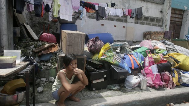A girl guards her belongings as demolition begins at an informal settlers' community in the Philippines on September 30.