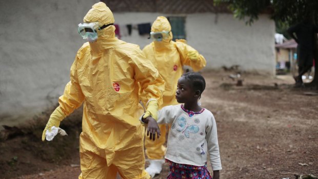 A young girl is taken to an ambulance after showing signs of the Ebola infection in Liberia during the 2014 outbreak.