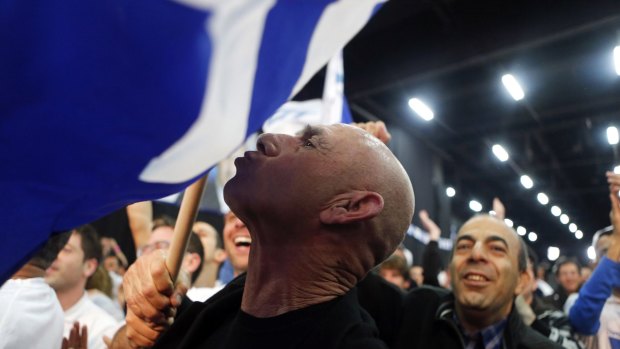 A Likud supporter reacts after hearing exit poll results in Tel Aviv on Tuesday.