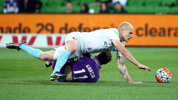 Down but not out: Aaron Mooy of Melbourne City is brought down in a challenge by Richard Garcia of Perth Glory.