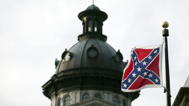The Confederate battle flag flutters in the breeze in front of the South Carolina state house.