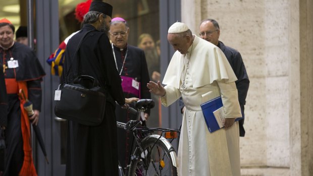Pope Francis blesses the bicycle of a prelate participating in the Synod at the Vatican on Wednesday. 