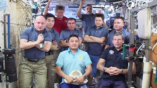 Scott Kelly, left, has his arms folded as he takes part in  a news conference by the then nine-member International Space Station crew in August last year.