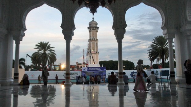 People gather at Baiturrahman Grand Mosque at dusk in Banda Aceh, Aceh province, Indonesia. A local law that makes gay sex punishable by public caning took effect in October last year.