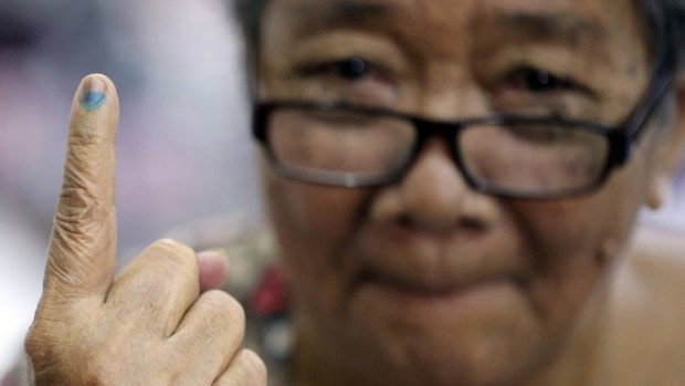 An 80-year-old Filipina, Dioleta Esteban, shows the indelible ink on her finger after casting her votein suburban San Juan, east of Manila, on Monday. 