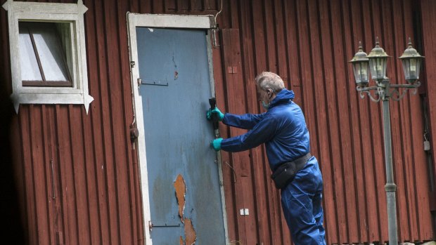A police forensic officer works at a property outside Knislinge in southern Sweden where the 38-year-old woman was allegedly taken. 