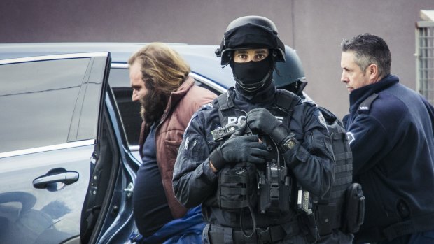 Phillip Galea is led from a house by police during a terror raid in Braybrook.