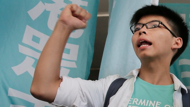Barred: Teen protest leader Joshua Wong shouts slogans outside a magistrate's court in Hong Kong, in July.