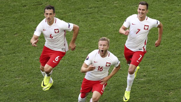 Poland's goalscorer Jakub Blaszczykowski celebrates with teammtes Poland's Tomasz Jodlowiec, left, and Arkadiusz Milik, 