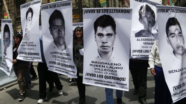 Students from the Universidad Mayor de San Andres of Bolivia hold banners with photos of the 43 disappeared students in Mexico.