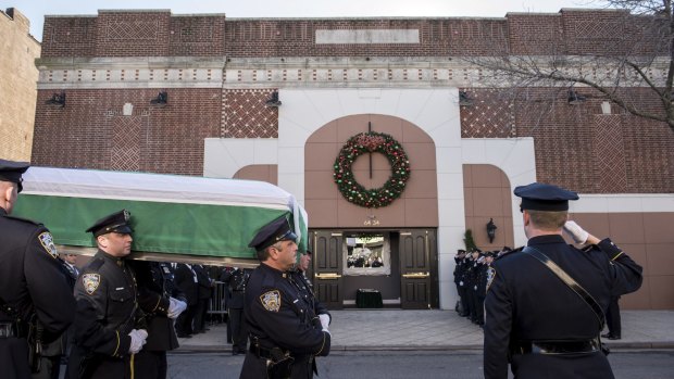 New York Police Department personnel bear the casket of  Rafael Ramos.