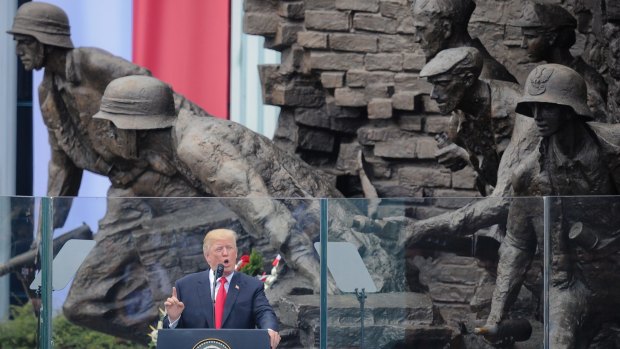 President Donald Trump speaking in Krasinski Square, back dropped by the monument commemorating the 1944 Warsaw Uprising.