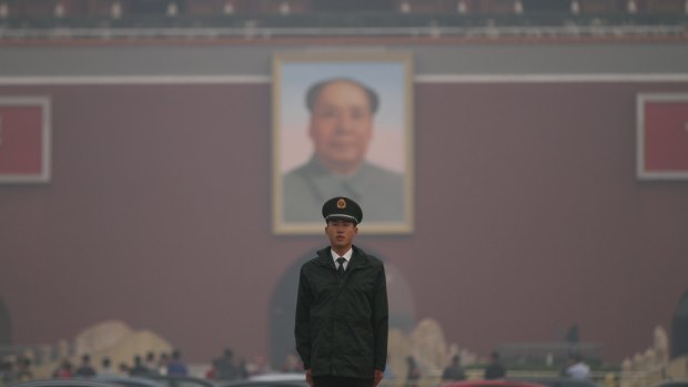 A police officer on guard in Tiananmen Square as smog engulfs Beijing in October: an environmental disaster that may be alleviated by President Obama's US-China carbo-capping accord.