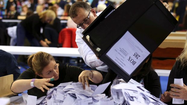 Ballot boxes are emptied to be counted in Glasgow, Scotland, on Thursday.