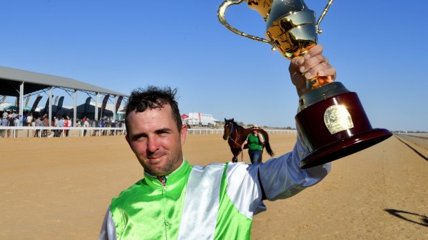 Jockey Adrian Comme celebrates winning the Birdsville Cup on Saturday after riding Fast Fella.