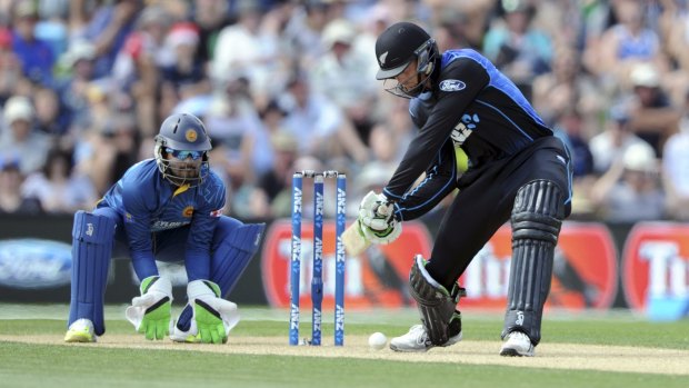 New Zealand's Martin Guptill winds up for a big hit as Sri Lanka's Dinesh Chandimal looks on.