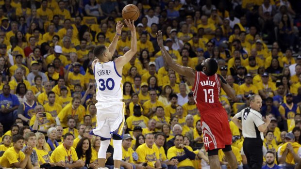 Perfect form: Golden State Warriors star Stephen Curry makes a three-pointer over Houston Rockets guard James Harden.