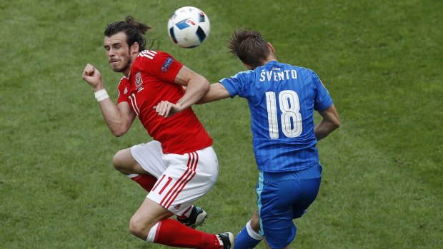 Aerial challenge: Wales star Gareth Bale jumps for the ball with Slovakia's Dusan Svento.