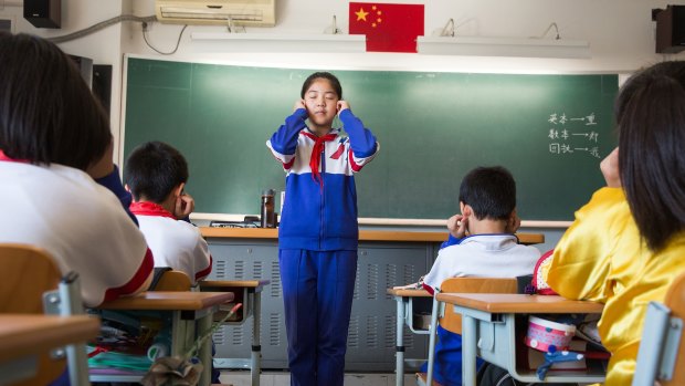In a Primary 5 class at Jingshan School, one of Beijing's most elite schools, pupils take a few minutes to do eye exercises to help relax their eyes.