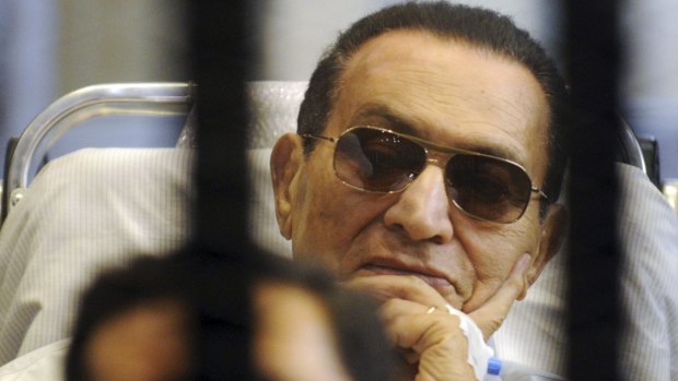Former Egyptian President Hosni Mubarak sits inside a cage in a courtroom at the police academy in Cairo in 2013.
