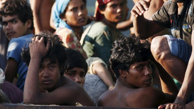 Illegal migrants and asylum-seekers aboard a boat tethered to a Thai navy vessel on Saturday. 