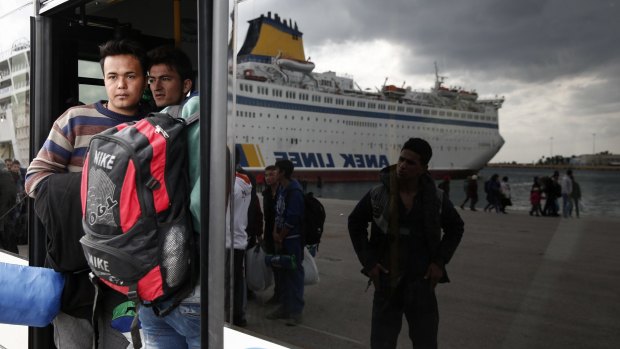 Migrants and refugees board a bus after arriving from the north-eastern Greek islands of Lesbos and Chios at the Athens' port of Piraeus on Sunday. The EU chose Lesbos to test a new fast-track registration process that if successful will be rapidly expanded to other crisis areas.