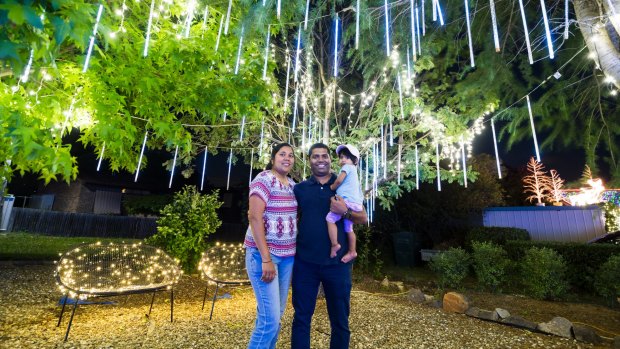 Jessica and  Antony Michaelson with one-year-old  Sophia under the famous Christmas lights in Bissenberger Crescent in Kambah.