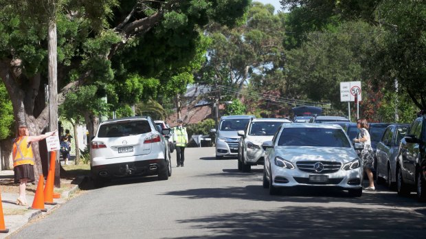 A car is told to move on after stopping in the middle of Kambala Road during after-school pick-up at Scots College on Friday.