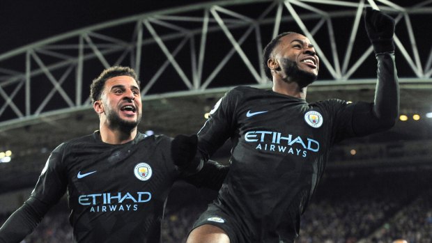 Manchester City's Raheem Sterling (right) celebrates with teammate Kyle Walker after scoring against Huddersfield Town.