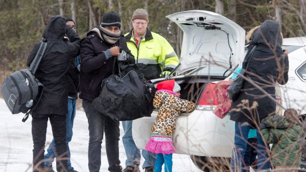 A group of refugee claimants from Eritrea arrive by taxi to cross the border from New York into Canada on March 2.