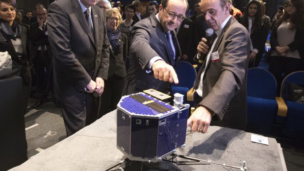 French President Francois Hollande looks at a model of Rosetta lander Philae in 2014.