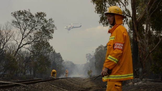 CFA firefighter put out railway sleepers along the Stony Point railway line, near Somerville, on Tuesday..