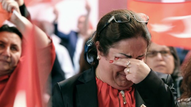 A woman reacts while watching a live broadcast of the Turkish referendum results.