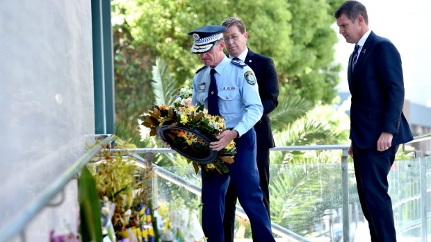 NSW Police Commissioner Andrew Scipione lays a wreath at a floral tribute for police accountant Curtis Cheng outside police headquarters in Parramatta on Tuesday, while Police Minister Troy Grant and Premier Mike Baird look on.