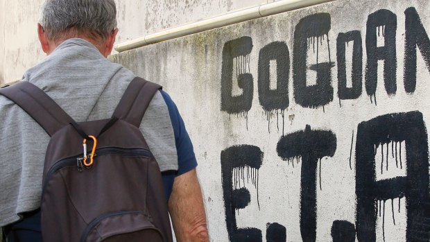 A man walks past graffiti reading 'ETA  Basque country and Freedom', in Sare, south-western France, on April 7, 2017. 