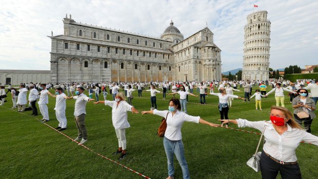 People gather for a flash mob on the Miracle's square to celebrate the reopening of the Leaning Tower.