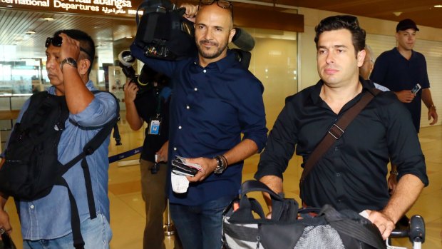 Reporter Linton Besser, right, and camera operator Louie Eroglu prepare to leave at Kuching International Airport.