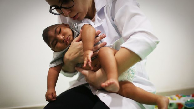 A physical therapist working with a  baby born with microcephaly in Recife, Brazil. 