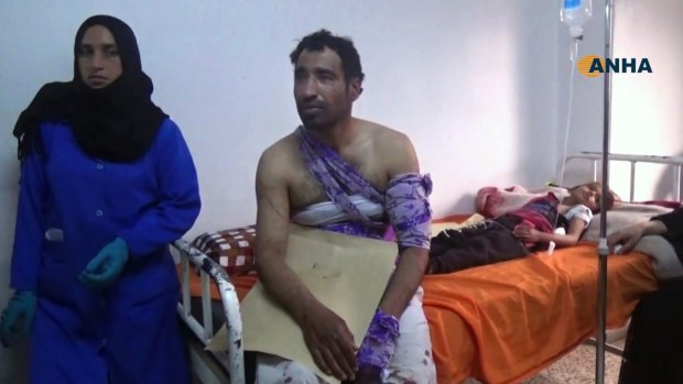 This frame grab from video provided by the Hawar News Agency, shows people wounded in an attack by the Islamic State group receiving treatment at a clinic in Hasakeh province, Syria.