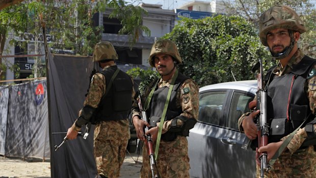 Pakistani soldiers stand alert at the site of an explosion, in Lahore, Pakistan.