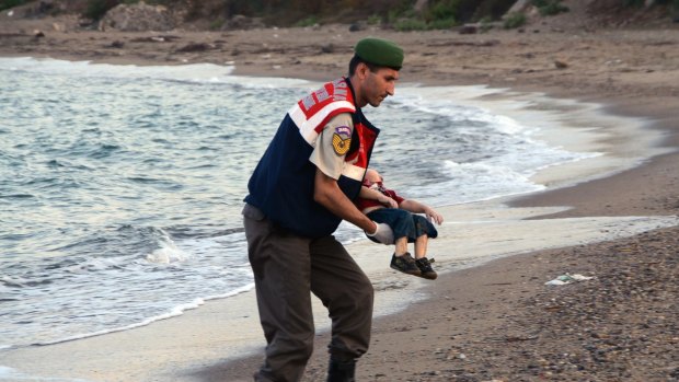 A paramilitary police officer carries the lifeless body of Aylan Kurdi, 3, after a number of migrants died and others were reported missing when boats carrying them to the Greek island of Kos capsized near the Turkish resort of Bodrum. 