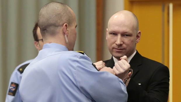 Anders Behring Breivik has his handcuffs removed after entering the courtroom in Skien.