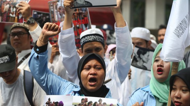 Indonesian activists hold poster during a protest in front of the Myanmar Embassy in Jakarta, Indonesia.