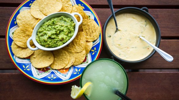 Con queso and guacamole dips with corn chips.