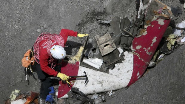 A French rescue worker inspects the remains of the Germanwings Airbus A320 at the site of the crash.
