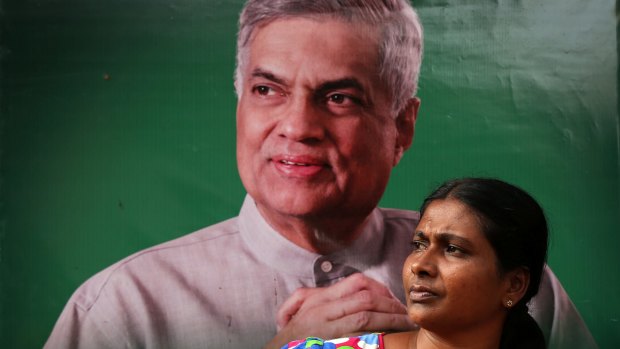 A supporter of United National Party in front of party leader Ranil Wickremasinghe's poster. He will now be sworn in again as prime minister.