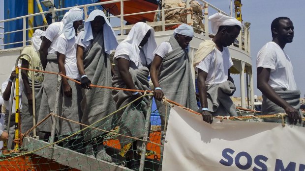 Migrants disembark from the SOS Mediterranee ship Aquarius at the Lampedusa harbor, Italy, on Monday.