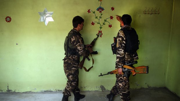 Afghan security forces look at a Taliban mark on the wall in one of their captured centres, following weeks of heavy clashes to reclaim an area from Taliban militants in Baghlan province, north of Kabul, Afghanistan.
